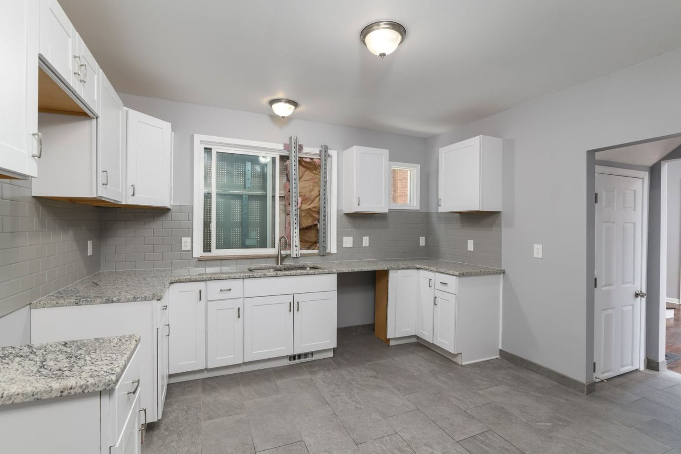 Rental-ready kitchen with white cabinets and granite counters